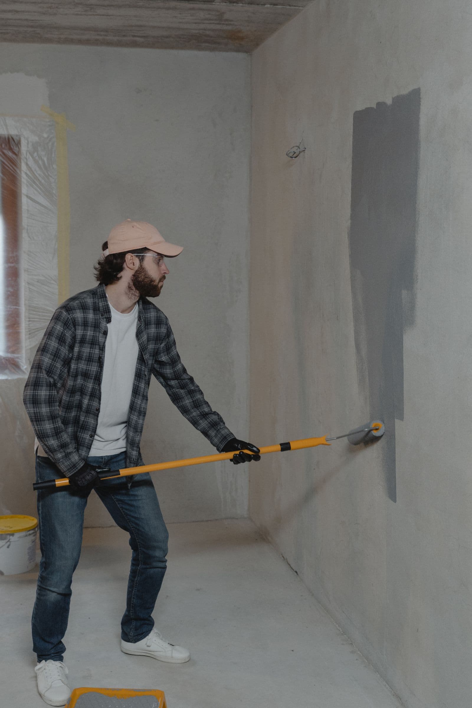 Painter using a roller with both hands during an interior home renovation